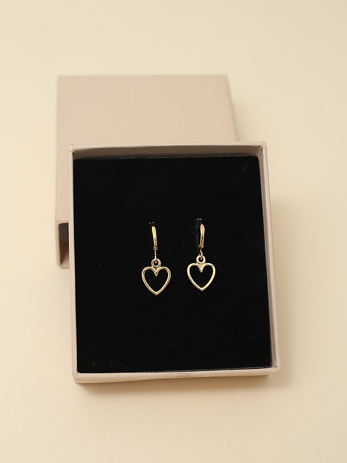 Elegant gold heart drop earring with a minimalist design, perfect for everyday wear or special occasions, showcasing a delicate heart charm hanging gracefully.