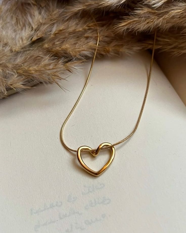 Gold heart-shaped necklace on a soft surface with fur texture