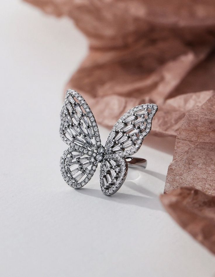 Butterfly-shaped ring with diamond accents on a light background