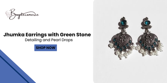 Traditional Jhumka earrings with intricate detailing, green stone accents, and pearl drops displayed on a white backgroud