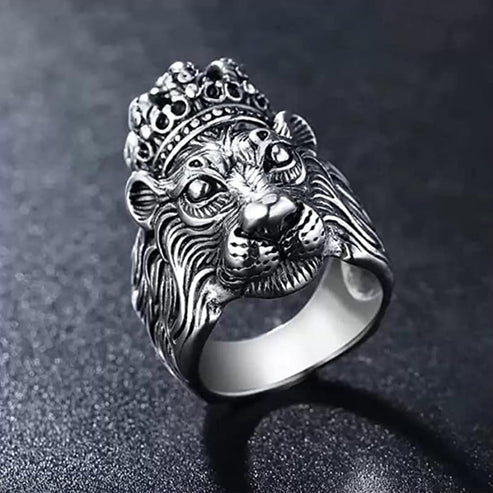 Silver lion head ring with a crown on a dark background