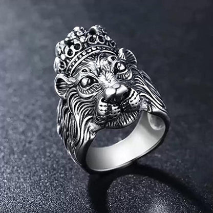 Silver lion head ring with a crown on a dark background