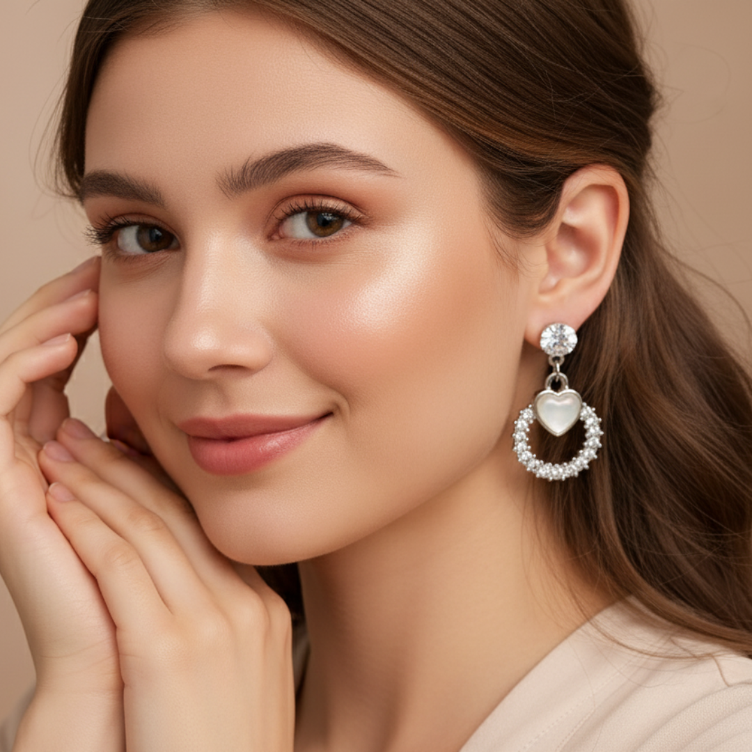 Woman wearing a silver earring with a heart and circular design on a beige background