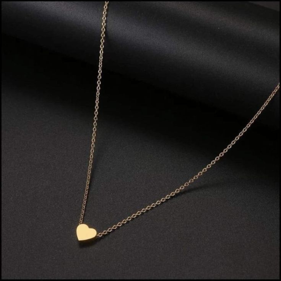 Gold heart-shaped necklace on a dark fabric background