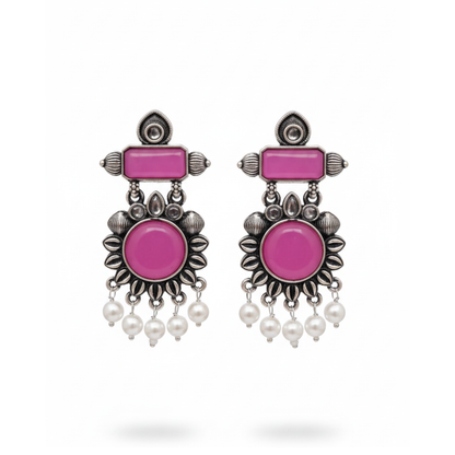 Pair of earrings with pink stones and pearl-like beads on a white background